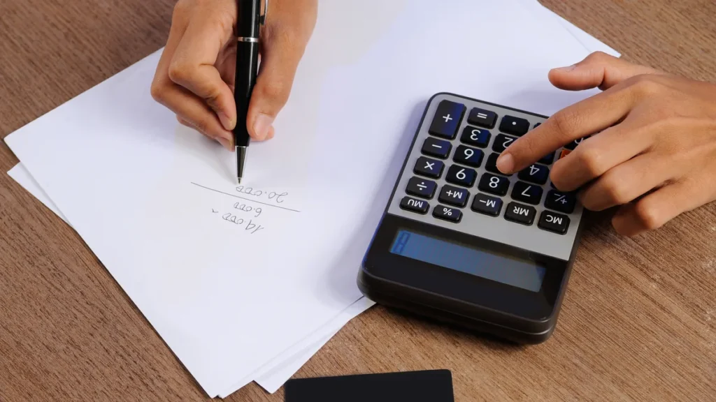 Contrato e calculadora sobre a mesa para calcular a multa por desistência de consórcio e comparar com a venda da cota